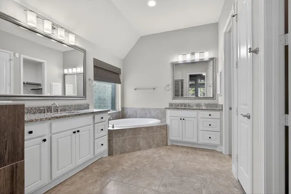 a spacious bathroom with a granite countertop sink mirror and a