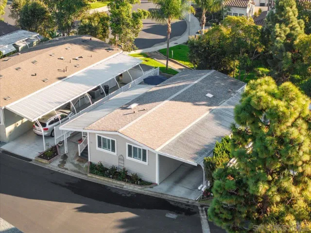 an aerial view of a house with a yard and a large tree
