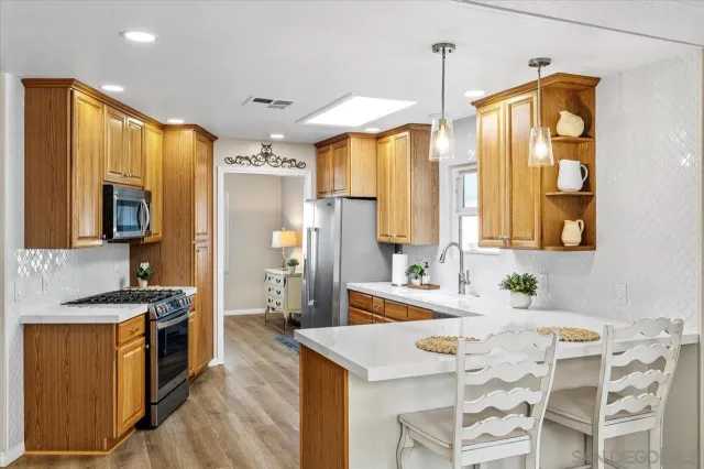 a spacious kitchen with stainless steel appliances a sink stove and refrigerator