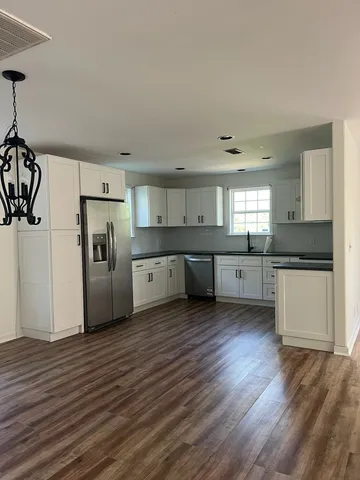 a kitchen with granite countertop white cabinets sink and window