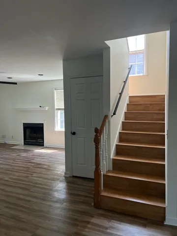 a view of a livingroom with wooden floor and staircase