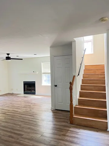 a view of empty room with wooden floor and fireplace