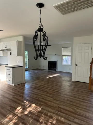 a large kitchen with cabinets wooden floor and stainless steel appliances