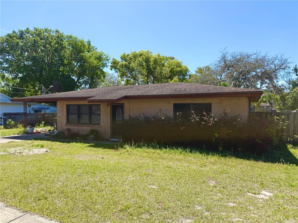 a front view of house with yard and trees in the background