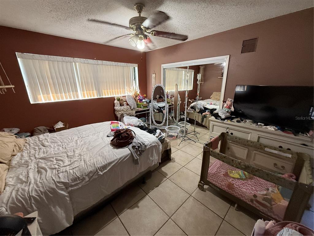 460 West Pierce Street Lake Alfred, FL 33850 - Photo 27 of 41 a bedroom with bed a flat tv screen and a dresser