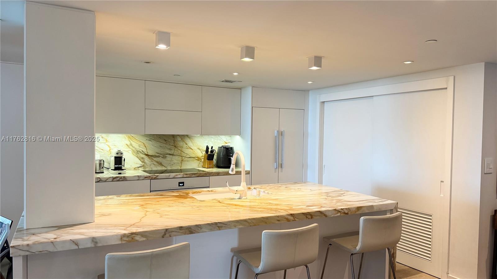 2101 Brickell Avenue, Unit 1012 Miami, FL 33129 - Photo 26 of 40 a kitchen with stainless steel appliances granite countertop a sink and a refrigerator