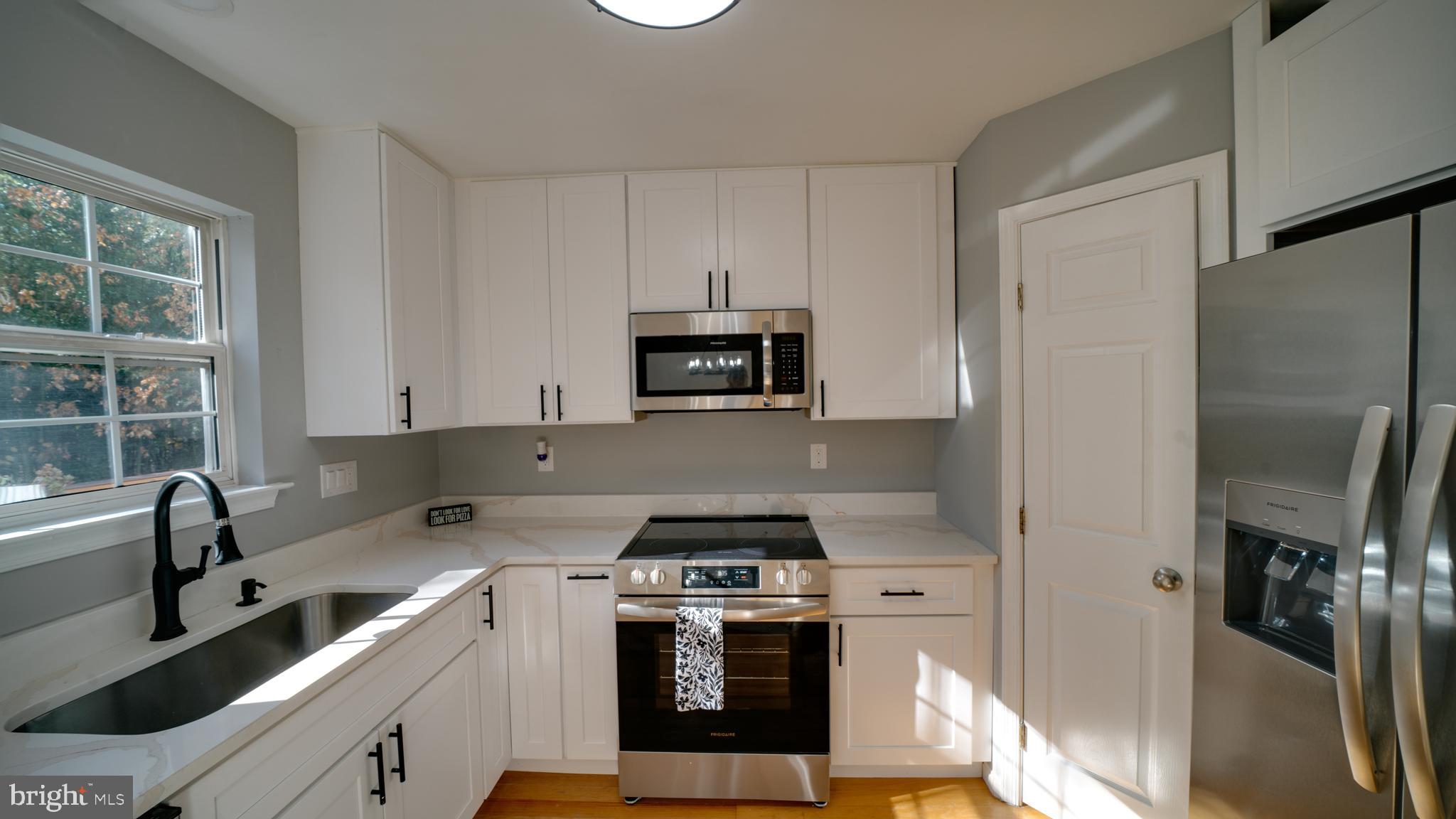 6934 Village Stream Place Gainesville, VA 20155 - Photo 15 of 31 a kitchen with a stove and a refrigerator