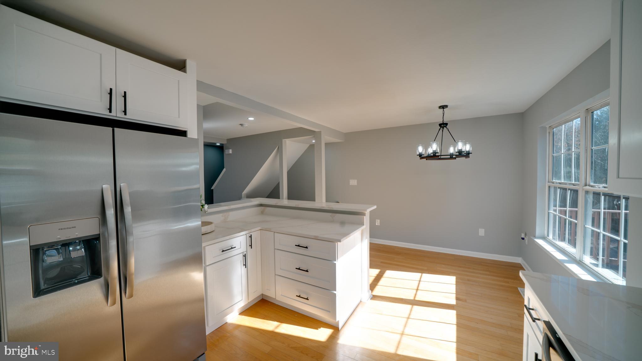 6934 Village Stream Place Gainesville, VA 20155 - Photo 16 of 31 a view of kitchen with stainless steel appliances wooden floor and window