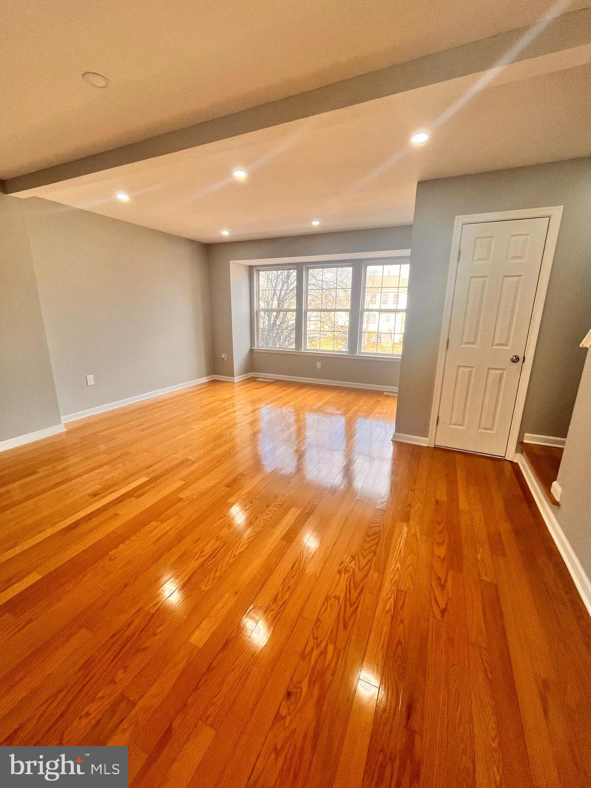 6934 Village Stream Place Gainesville, VA 20155 - Photo 18 of 31 a view of an empty room with wooden floor and a window