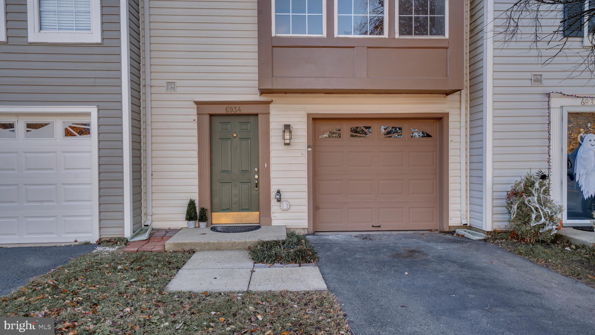 6934 Village Stream Place Gainesville, VA 20155 - Photo 2 of 31 a front view of a house with garden