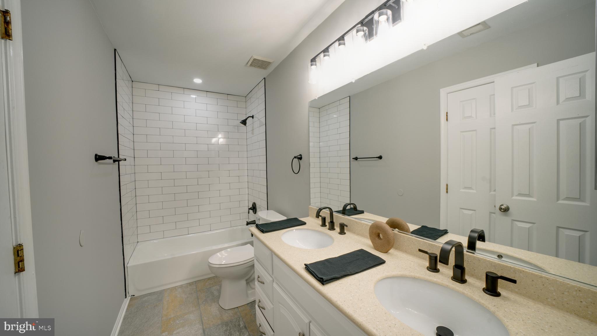 6934 Village Stream Place Gainesville, VA 20155 - Photo 25 of 31 a bathroom with a sink a toilet and shower
