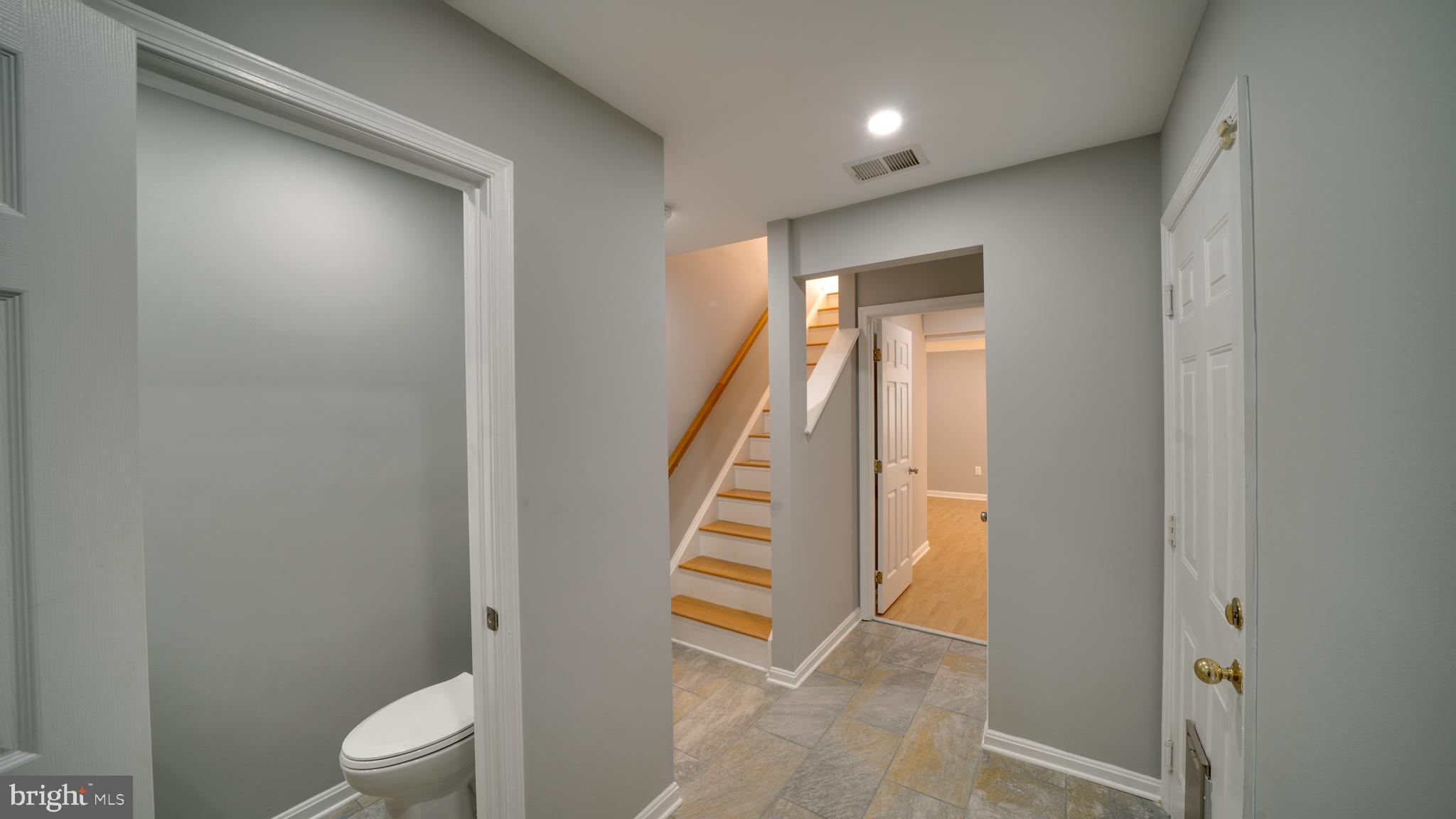 6934 Village Stream Place Gainesville, VA 20155 - Photo 3 of 31 a view of a hallway with wooden floor and stairs