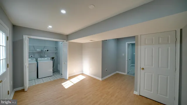 a view of empty room with wooden floor and window