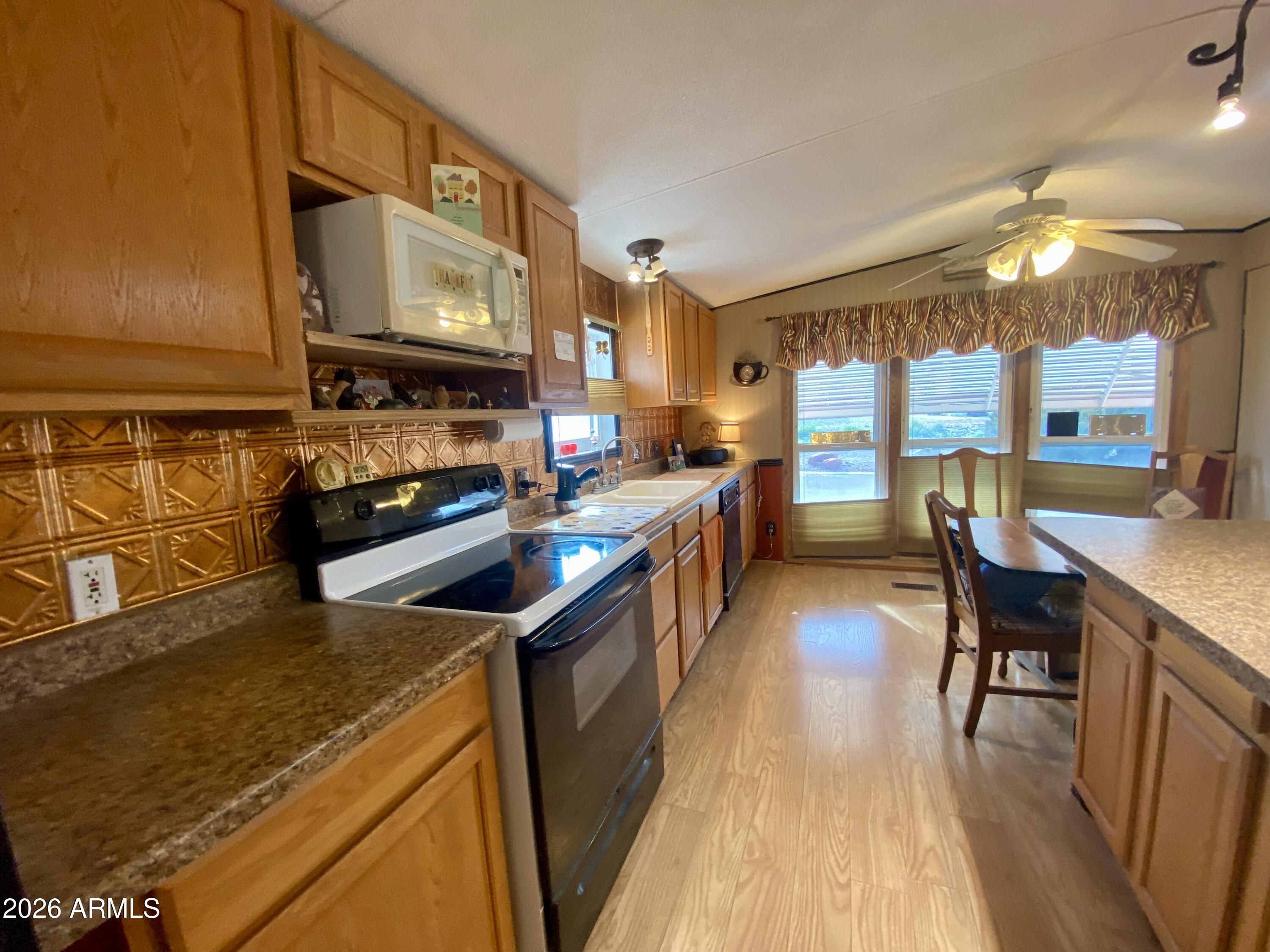 723 Finnie Flat Road, Unit 103 Camp Verde, AZ 86322 - Photo 14 of 41 a kitchen with stainless steel appliances granite countertop sink stove top oven and cabinets