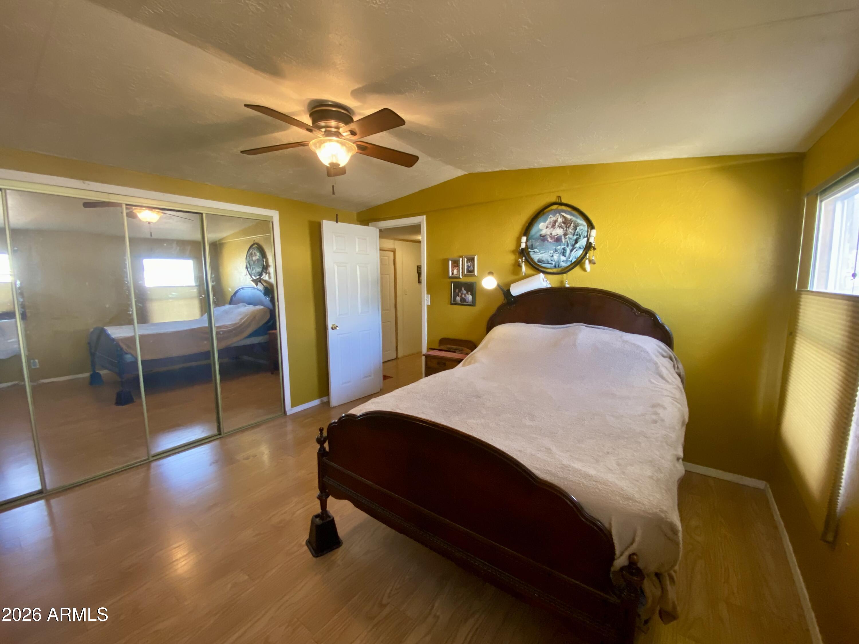 723 Finnie Flat Road, Unit 103 Camp Verde, AZ 86322 - Photo 27 of 41 a bedroom with a bed and a chandelier