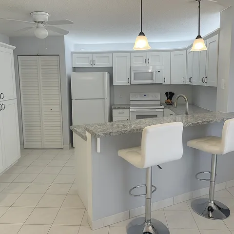 a kitchen with kitchen island a counter top space cabinets and a sink