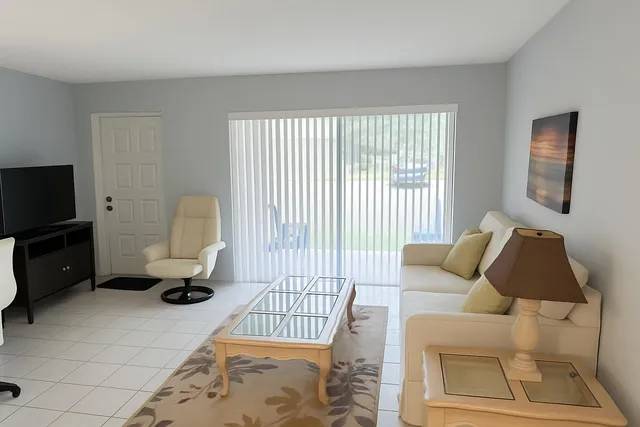 a living room with furniture a rug and a window