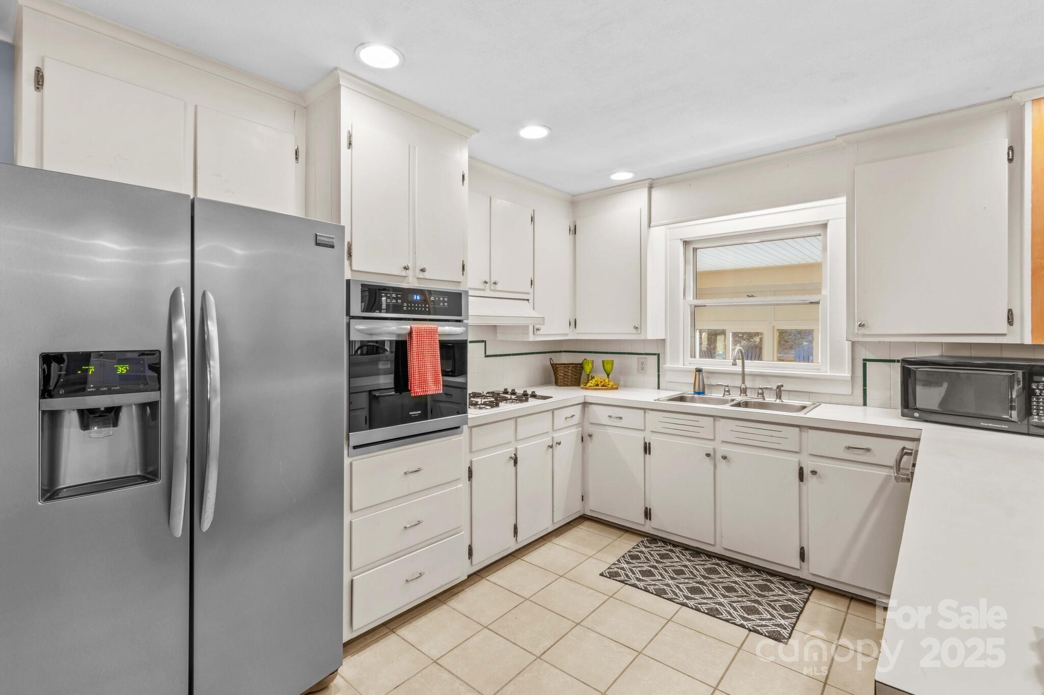 1231 Maxwell Street Salisbury, NC 28144 - Photo 15 of 42 a kitchen with white cabinets stainless steel appliances and a window