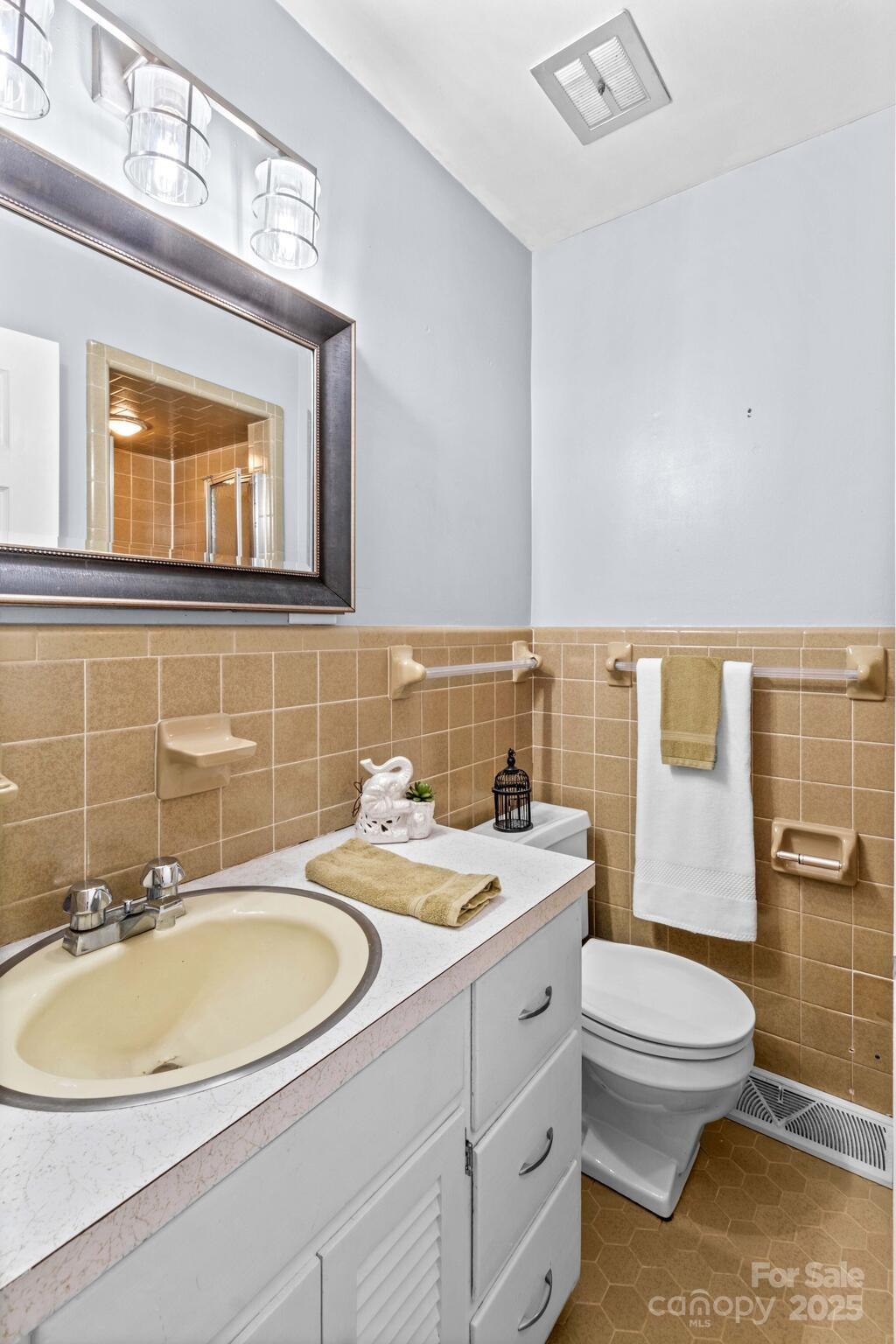 1231 Maxwell Street Salisbury, NC 28144 - Photo 19 of 42 a bathroom with a granite countertop toilet a sink and a mirror