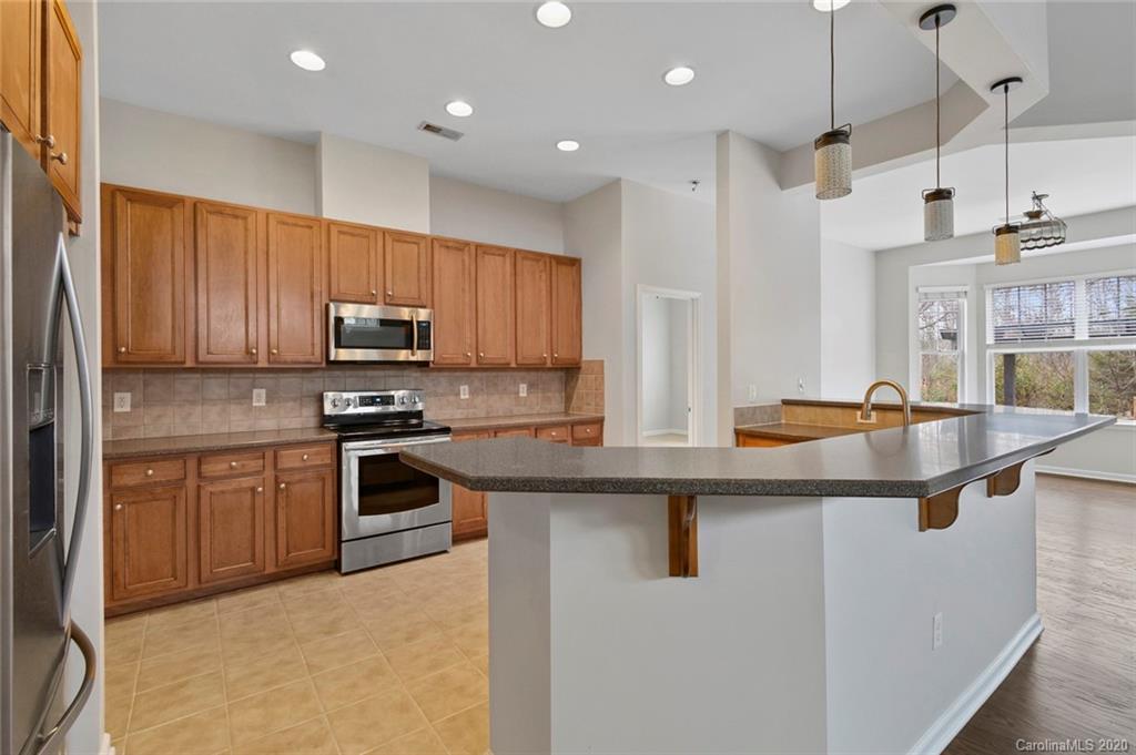 268 Sand Paver Way Fort Mill, SC 29708 - Photo 12 of 23 a kitchen with stainless steel appliances granite countertop a sink a stove a refrigerator cabinets and living room view