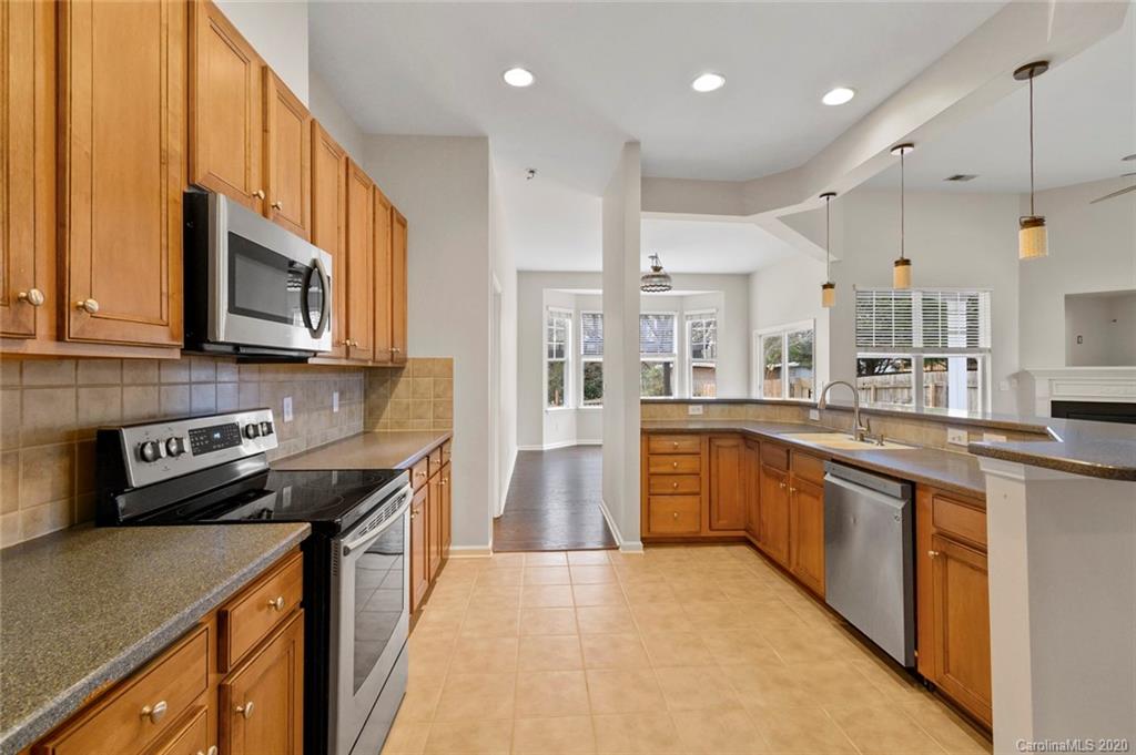 268 Sand Paver Way Fort Mill, SC 29708 - Photo 13 of 23 a kitchen with stainless steel appliances granite countertop a sink a stove top oven a refrigerator cabinets and wooden floor
