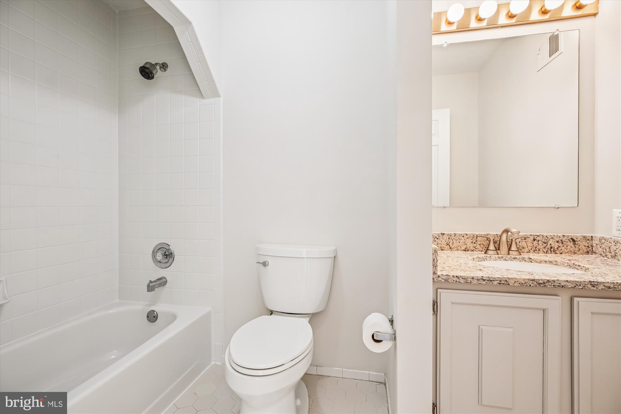 17 Locustwood Court Silver Spring, MD 20905 - Photo 54 of 72 a bathroom with a granite countertop toilet a sink and a bathtub