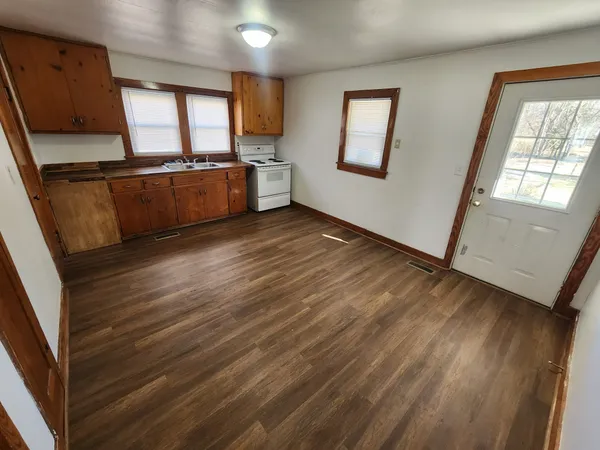 a view of a kitchen with wooden floor and electronic appliances