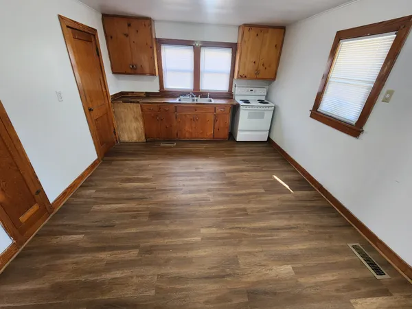 a room with wooden floor and cabinets