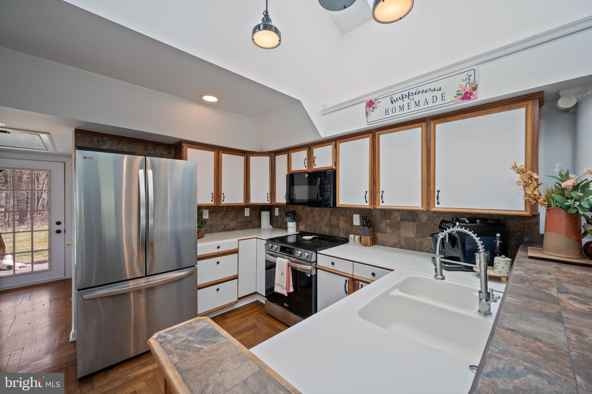 13403 Catoctin Furnace Road Thurmont, MD 21788 - Photo 11 of 60 a kitchen with stainless steel appliances a refrigerator a sink a stove and cabinets
