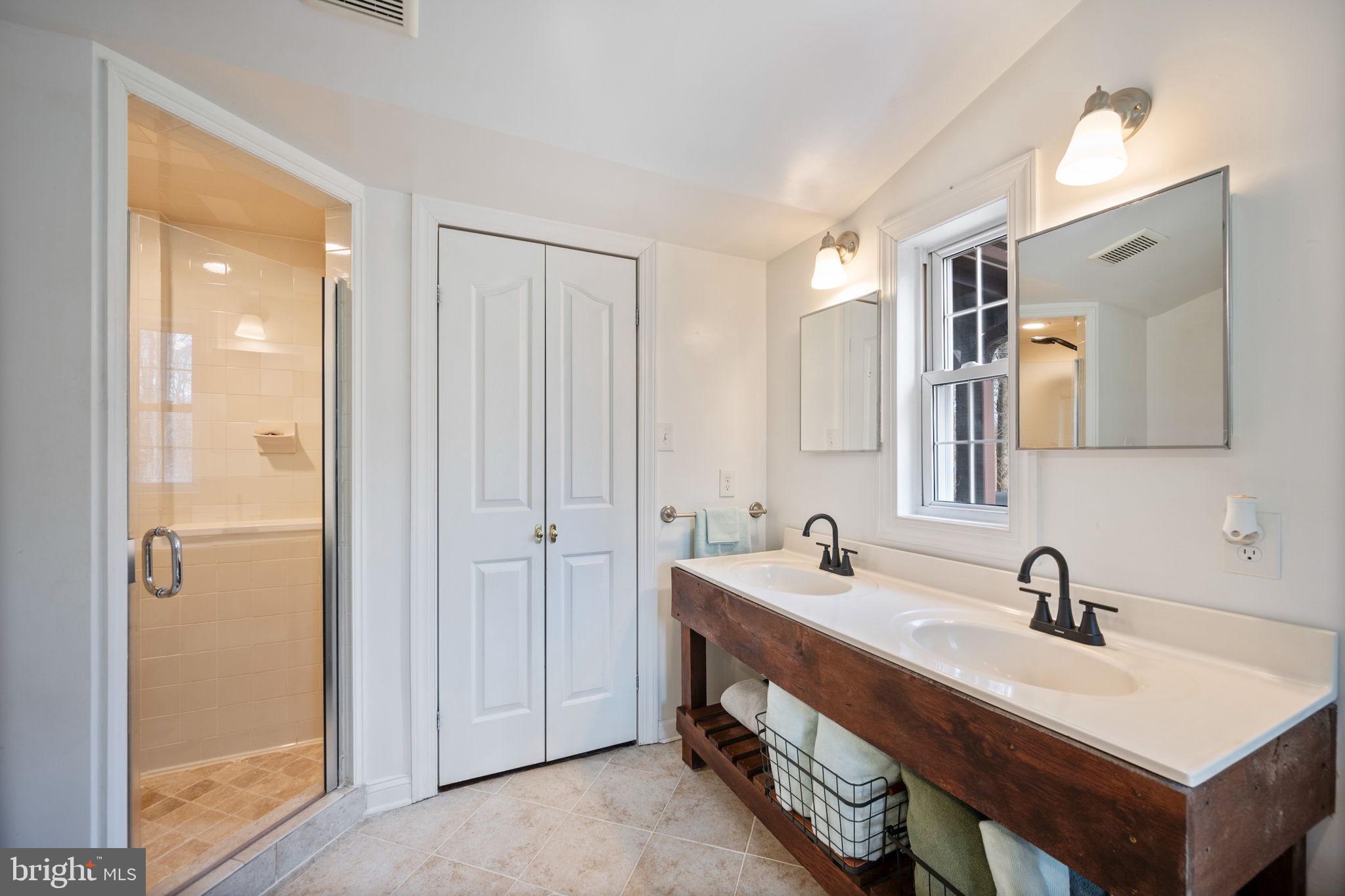13403 Catoctin Furnace Road Thurmont, MD 21788 - Photo 21 of 60 a bathroom with a double vanity sink mirror and shower