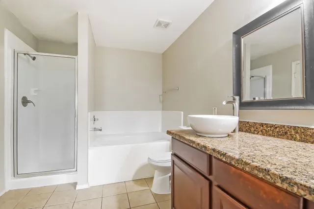 a bath room with a granite countertop sink and a mirror