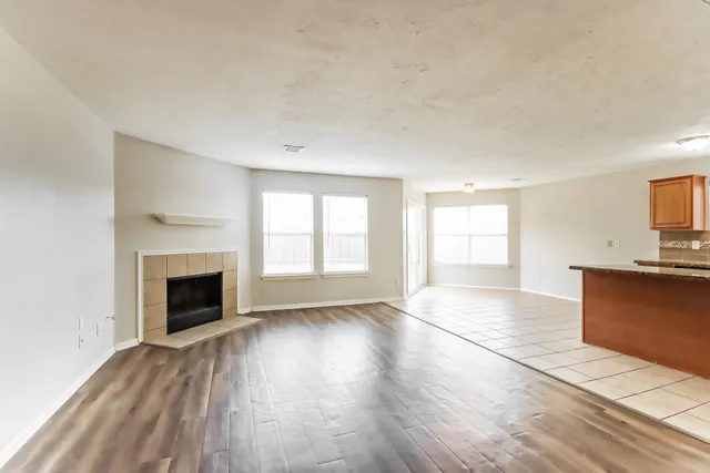 wooden floor fireplace and windows in an empty room