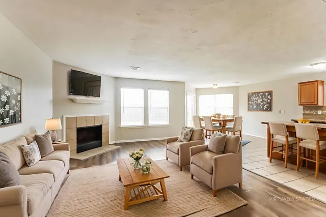 a living room with furniture a fireplace and a flat screen tv