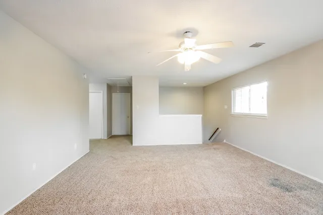 a view of a big room with windows and chandelier fan