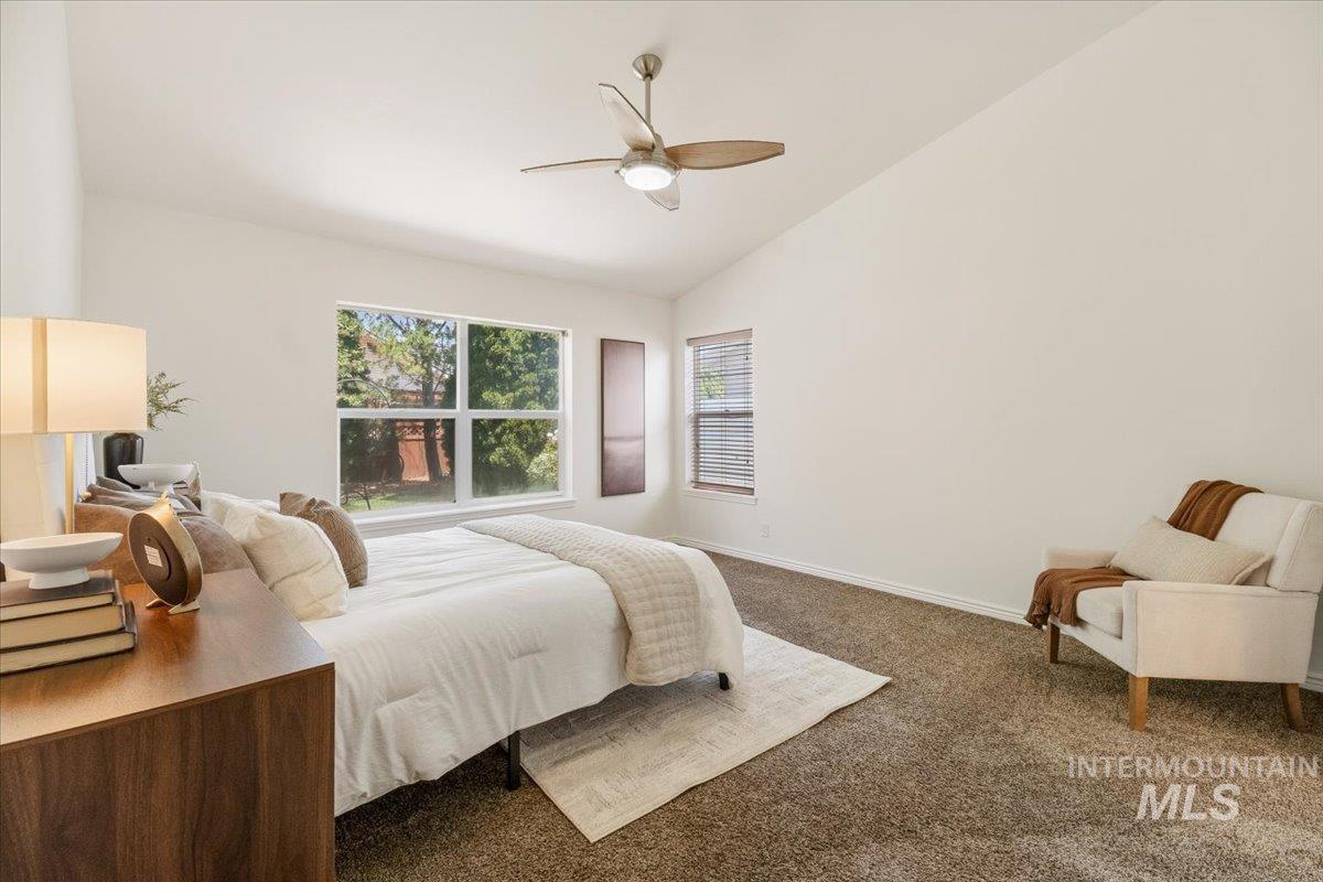 2032 Talus Loop Twin Falls, ID 83301 - Photo 29 of 43 Bedroom featuring a vaulted ceiling, large window, additional window with blinds, ceiling fan, and carpet flooring