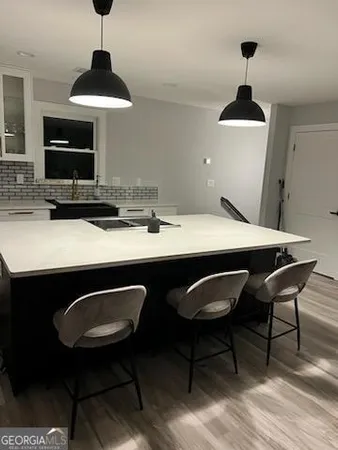 a kitchen with a dining table chairs and a wooden floor