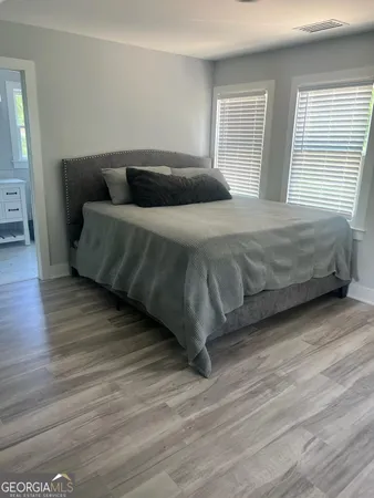a bedroom with a bed and wooden floor
