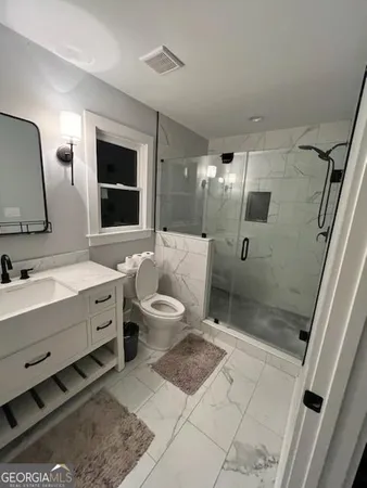a bathroom with a double vanity sink toilet mirror and bathtub