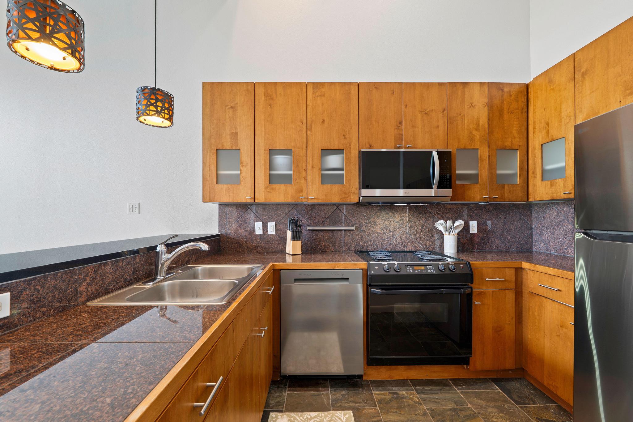 2918 Ranch Road 620, Unit J162 Austin, TX 78734 - Photo 5 of 26 Kitchen featuring wood cabinetry, stainless steel appliances, dark tile countertops, and a stone tile backsplash