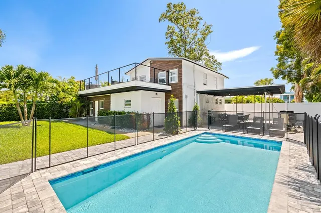 a view of a swimming pool with a patio and a yard