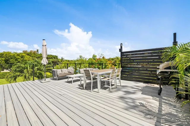 a view of a patio with table and chairs with wooden floor and fence