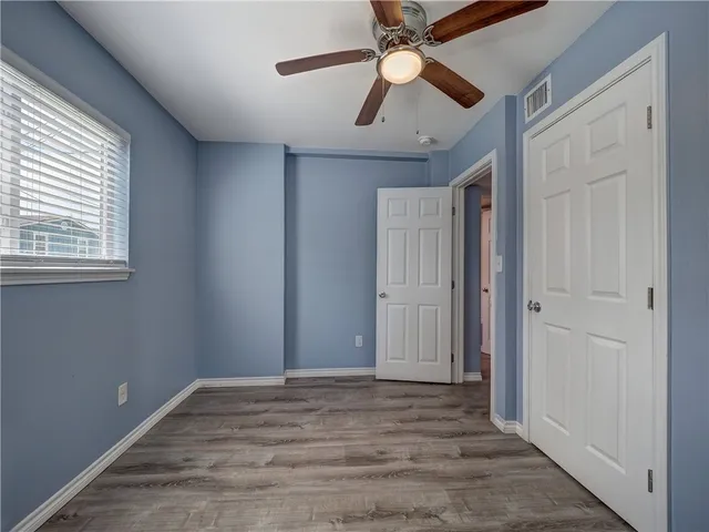a view of a kitchen with wooden floor and a ceiling fan