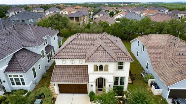 an aerial view of a house with a yard and trees