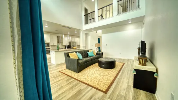 a living room with furniture and a view of kitchen