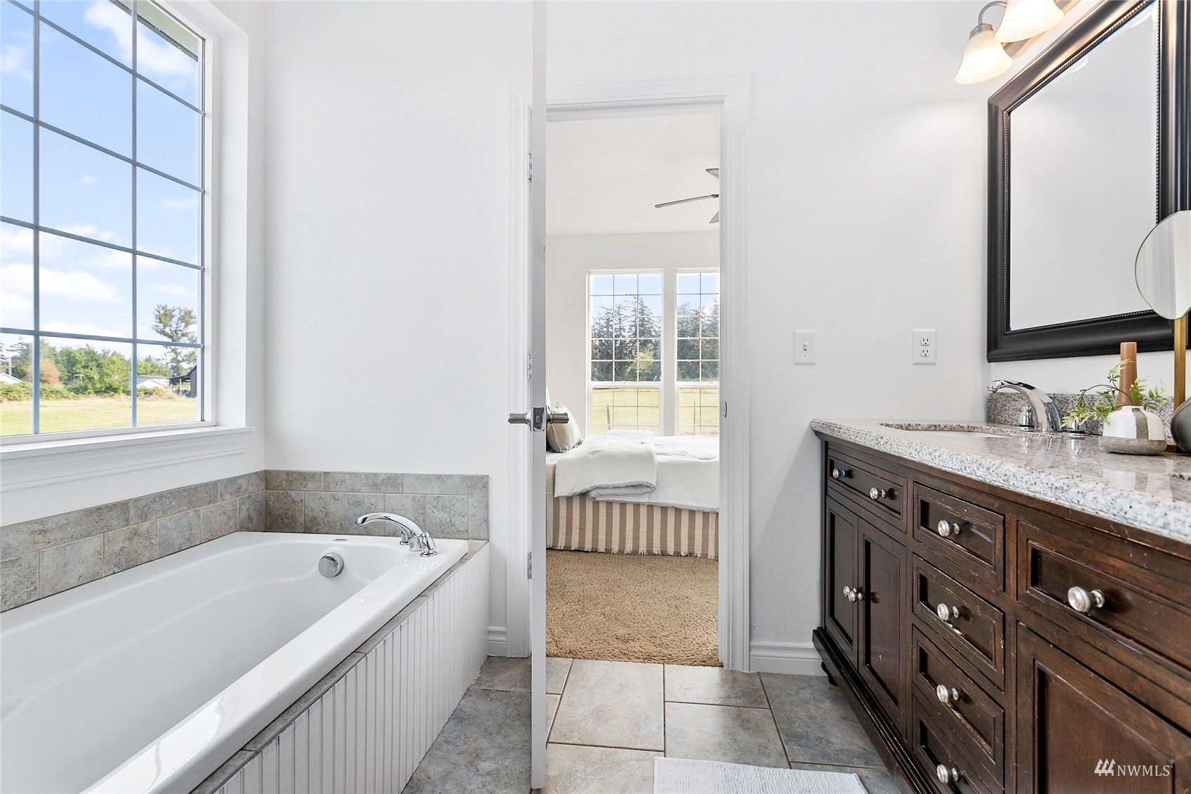 4906 Graveline Road Bellingham, WA 98226 - Photo 16 of 30 a bathroom with a granite countertop tub a sink and a window