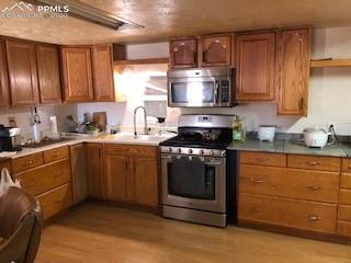 38120 Trogilo Road Rush, CO 80833 - Photo 13 of 16 a kitchen with stainless steel appliances granite countertop a stove a sink dishwasher and a refrigerator