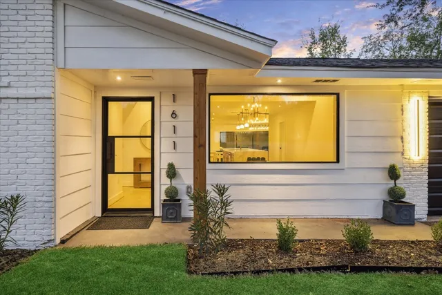 a view of house front with a garden