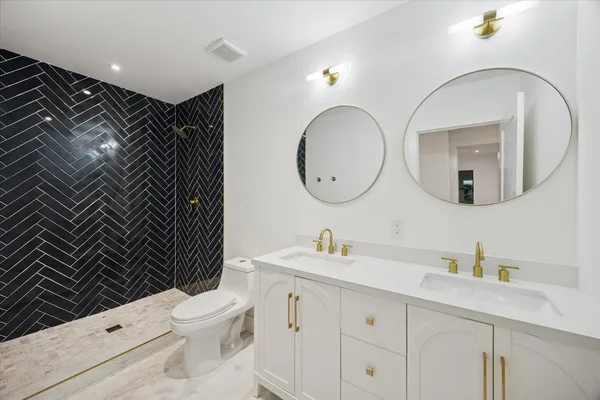 a bathroom with a sink mirror vanity and toilet