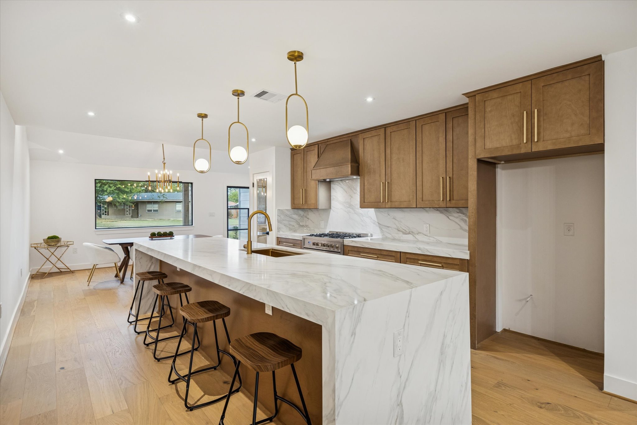 1611 Ridgehaven Drive Austin, TX 78723 - Photo 5 of 35 a kitchen with kitchen island a stove a table and chairs in it