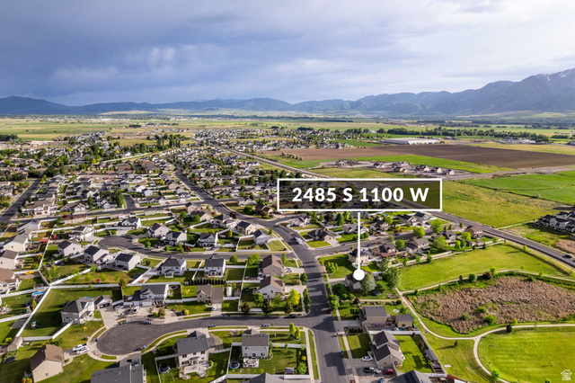 2485 South 1100th Street West Logan, UT 84321 - Photo 53 of 53 Aerial perspective showcasing a residential neighborhood with surrounding green spaces and distant mountains